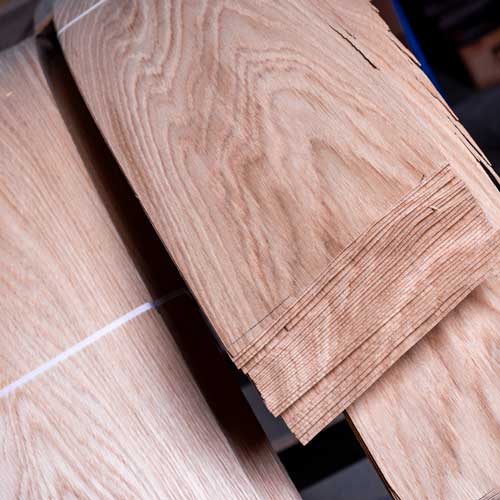 Finer-klar-til-fronter Usorteret finér fra ét træ. Alt finér bliver håndsorteret og syet sammen på fabrikken. Det sorteres efter farve, og der gemmes ét stykke pr. ordre som referencefinér.