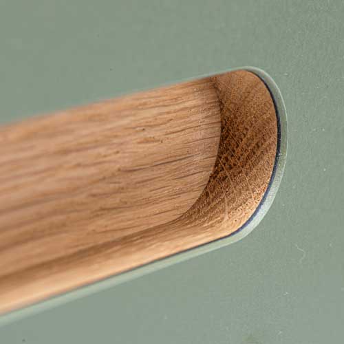 front-med-R15-greb-linoleum Grebet er lagt i spånpladen, hvorefter der er fræset ud til grebet. Her ses et R15-greb med en behagelig, blød og organisk form. Grebet kan monteres på alle 22 mm fronttyper i finér, laminat og linoleum.