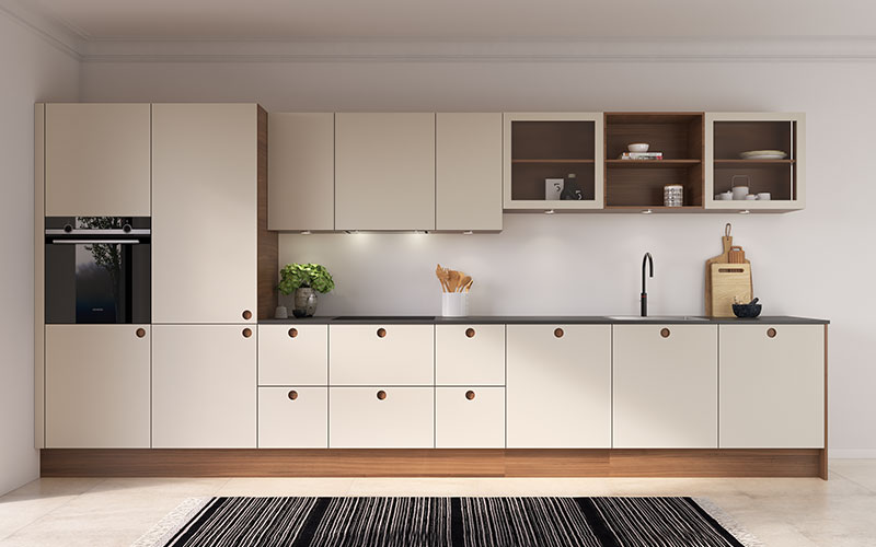 Køkkenets fronter er udført i mat linoleum, som tilfører rummet en blød, varm og indbydende overflade. Den rolige nuance Mushroom 4176 kombineret med valnødgreb og frisider skaber et harmonisk udtryk, hvor klassisk design møder hyggelig atmosfære i en smuk og unik helhed. Bag de ensartede fronter er både køleskab og opvaskemaskine elegant integreret, så køkkenet fremstår roligt og gennemført. I vitrineskabene fremhæver indbyggede LED-lys indholdet og giver en let og moderne stemning. Under alle overskabe er der yderligere arbejdslys, som sikrer et funktionelt og behageligt arbejdsområde. Det hele går op i en højere enhed – et køkken, hvor varme materialer og gennemtænkt design skaber en harmonisk og tidløs oplevelse.