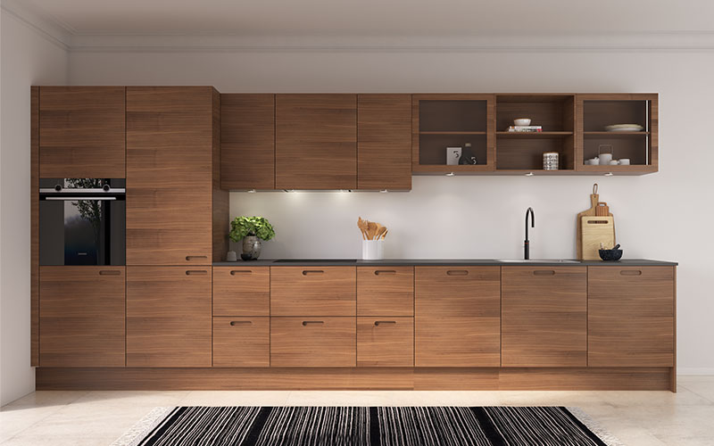 Køkkenets fronter er udført i den klassiske træsort valnød, hvilket skaber et smukt spil og passer perfekt til det klassiske hjem. Den varme farve udstråler elegance og tidløs klasse. Bag de stilrene fronter er både køle-fryseskab og opvaskemaskine diskret integreret, og alle sokler og gavle er udført i samme træ som fronterne, hvilket giver et gennemført udtryk. Indbygget lys i vitrineskabene tilføjer lethed og elegance, samtidig med at køkkenet giver mulighed for at sætte sit helt eget personlige præg.