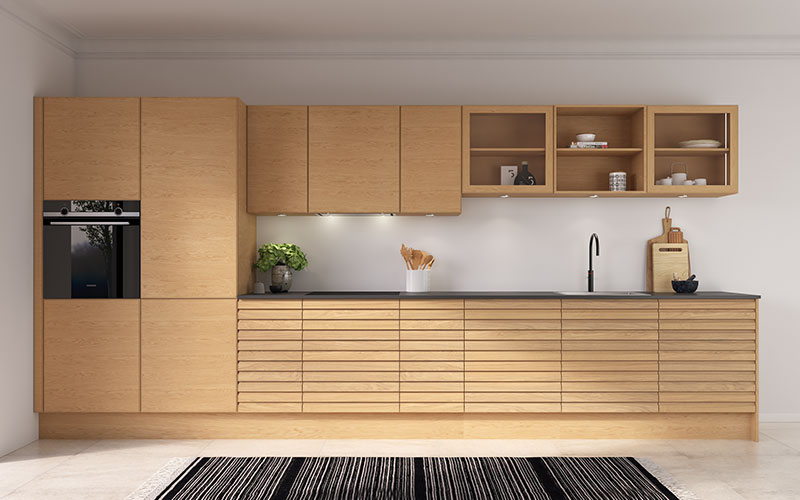 Dette køkken forener massivt træ og finér i en smuk og afbalanceret helhed, hvor naturens materialer får lov at dominere. Det er et fleksibelt køkken, der passer perfekt både i sommerhuset og den mindre lejlighed. Fronterne er udført i 19 mm S-Line massive lameller i natur Eg, som giver et levende og taktilt udtryk. Overskabe og højskabe er designet uden greb med den diskrete L11-profil, så betjeningen foregår via push-funktion for et rent og moderne look. Bag de enkle fronter finder man både køleskab og opvaskemaskine, og emhætten er integreret i overskabet, så den fremstår næsten usynlig. Reolerne er lavet i vandret egetræsfiner, hvilket tilfører varme og karakter til det naturlige design.