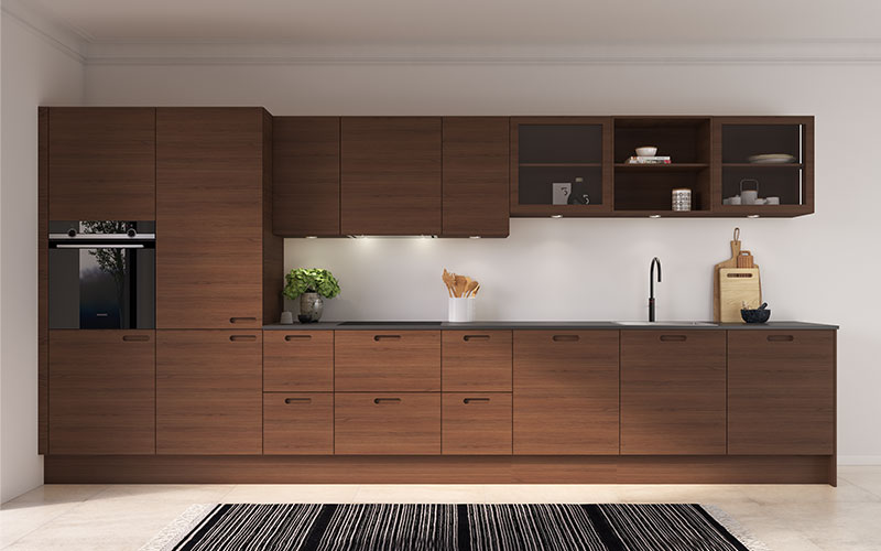 Køkkenet er varmt og funktionelt, med fronter i natur eg finér, der skaber ro og en hyggelig atmosfære. De elegante R15-greb kombinerer moderne linjer med et klassisk udtryk, hvilket giver køkkenet tidløs appel. Bag de stilrene fronter er både køleskab og opvaskemaskine diskret integreret. LED-lys i vitrineskabene fremhæver indholdet, og lys under alle overskabe sikrer et behageligt og effektivt arbejdsområde. Det er et køkken, der passer ind i stort set alle stilarter, fra det klassiske hjem til det moderne, minimalistiske miljø.